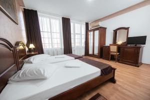 a bedroom with a bed and a desk with a mirror at Hotel Rion in Mangalia