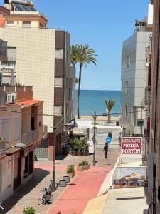 a city street with buildings and the ocean in the background at Apartamento Galvana in Peniscola