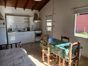 a kitchen and dining room with a table and chairs at Cabaña Alberto in Balneario Claromecó