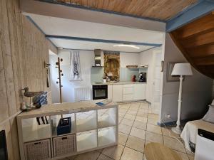 a kitchen with white cabinets and a table at penty vero in Plobannalec-Lesconil