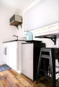 a kitchen with a black and white refrigerator and a stool at NEW! Cozy Container Home at Cliffside #5 in Orderville