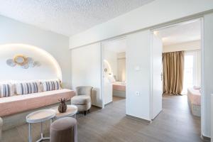 a bedroom with a bed and a table and a chair at SolMare Premium Suites in Mastihari