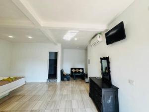 a living room with a flat screen tv on a wall at Hotel Pazifico en Monterrico in Monterrico