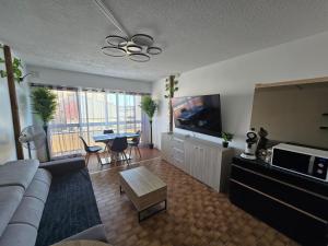 a living room with a couch and a tv and a table at Apparte 104 avec Jacuzzi in Cap d'Agde