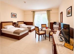 ein Hotelzimmer mit zwei Betten und einem Schreibtisch in der Unterkunft Penzion RAKI in Bratislava