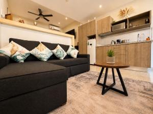 a living room with a black couch and a table at Syrena Luxury Caribbean - Heart of Playa del Carmen - Sea Views in Playa del Carmen