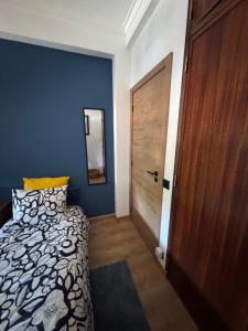 a bedroom with a bed and a wooden door at Margem Rio Residence in Sacavém
