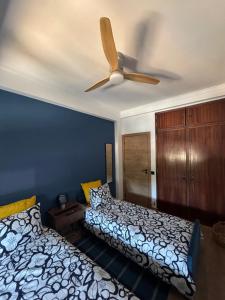 a bedroom with two beds and a ceiling fan at Margem Rio Residence in Sacavém