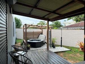a patio with a hot tub and a pergola at Résidence Morphée Tiny House avec Jacuzzi in Montjoly