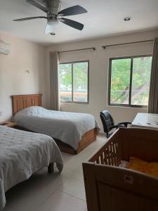 a bedroom with two beds and a ceiling fan at Casa Coco in Valladolid +58 photos