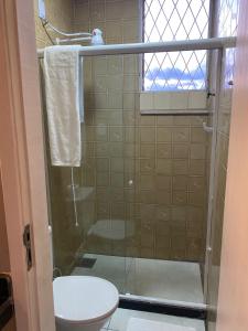 a bathroom with a shower with a toilet and a window at Loft Campinho 1 in Estação Inhoaíba