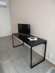 a black table in a room with a tv at Loft Campinho 1 in Estação Inhoaíba