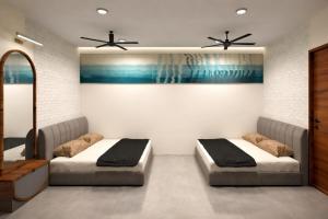 two beds in a room with two ceiling fans at विठाई AC Rooms in Pandharpur