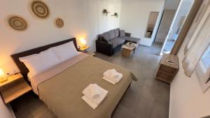 a bedroom with a bed and a living room at Anemos Comfort Living in Paralia Panteleimonos