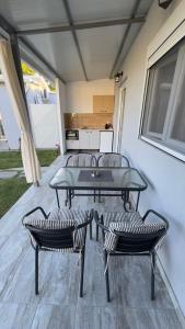 a patio with a table and two chairs and a kitchen at Anemos Comfort Living in Paralia Panteleimonos