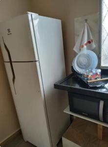 a refrigerator with a plate and a boat on a table at Loft Campinho 1 in Estação Inhoaíba