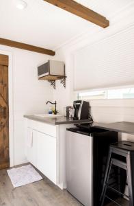 a kitchen with white cabinets and a sink at NEW! Cozy Container Home at Cliffside #5 in Orderville +13 photos