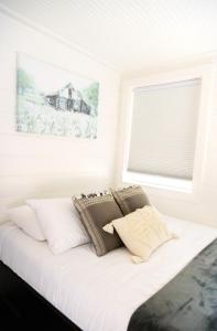 a bed with pillows on it in a room with a window at NEW! Cozy Container Home at Cliffside #5 in Orderville
