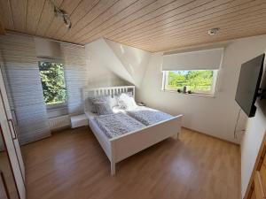 a bedroom with a bed and two windows at Ferienhaus Hofgut von Schaewen in Waldesch