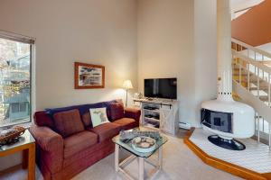 a living room with a couch and a fireplace at Hawks Nest 27 in Glen Arbor