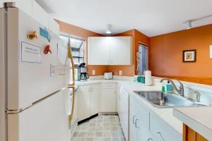 a kitchen with a white refrigerator and a sink at Hawks Nest 27 in Glen Arbor +11 photos