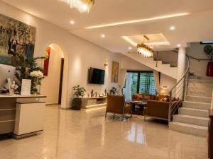 a living room with a staircase and a table and chairs at Maria Gracia House in Grand-Bassam