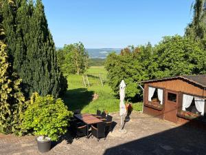 a patio with a table and chairs and a house at Ferienhaus Hofgut von Schaewen in Waldesch