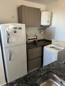 a kitchen with a white refrigerator and a sink at Shackleton in Wilde