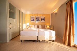 a bedroom with a large white bed and a chair at Circeo Park Hotel in San Felice Circeo +45 photos