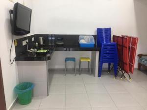 a room with a desk with two chairs and a television at LCS Homestay in Pangkor