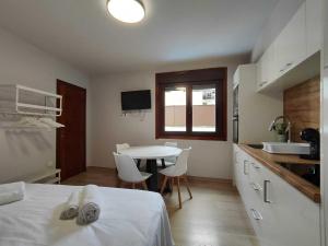 a bedroom with a table and a kitchen with a table and chairs at Habitación con cocina en Muralla Lugo 1.3 C in Lugo