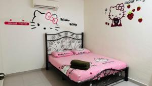 a bedroom with a pink bed with hello kitty stickers on the wall at LCS Homestay in Pangkor