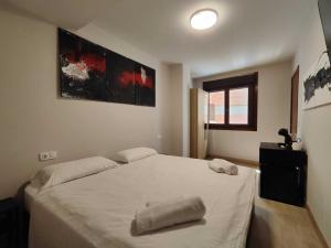 a bedroom with a large white bed with two towels on it at Habitación dentro de la Muralla de Lugo 1.3 B in Lugo +2 photos