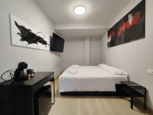 a bedroom with a white bed and a black desk at Habitación dentro de la Muralla de Lugo 1.3 B in Lugo