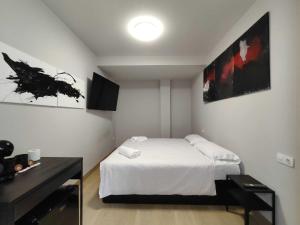 a bedroom with a white bed and a black desk at Habitación dentro de la Muralla de Lugo 1.3 B in Lugo