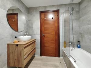 a bathroom with a sink and a tub and a mirror at Habitación dentro de la Muralla de Lugo 1.3 B in Lugo