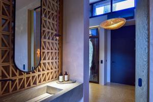 a hallway with a mirror and wine bottles on a counter at Karidi Beach Gaia Retreat in Vourvourou +55 photos
