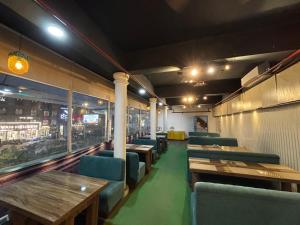 a dining room with wooden tables and green chairs at Hotel heritage luxeevista in Tājganj +6 photos