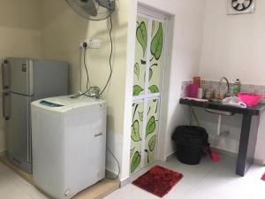 a kitchen with a refrigerator and a table in a room at LCS Homestay in Pangkor