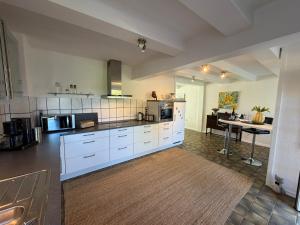 a kitchen with white cabinets and a table in it at Ferienhaus Hofgut von Schaewen in Waldesch