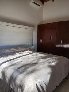 a bedroom with a large bed and wooden cabinets at Cabaña Alberto in Balneario Claromecó +6 photos