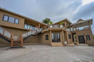 a large house with a staircase in front of it at Golden Pear Villa-MSV 10BR - 5 Fully Equipped Kitchens, Harbor & Sea Views in Morne Longue