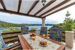 a table with a bowl of fruit and orange juice at House Vers in Vela Luka