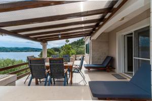a patio with a table and chairs and a view of the water at House Vers in Vela Luka +20 photos