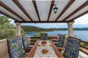 a table on a deck with a view of the water at House Vers in Vela Luka