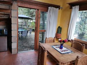 a kitchen and dining room with a table and a patio at Private Stunning Cottage In Forest Cuernavaca CDMX in Huertas de San Pedro
