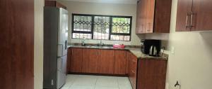 a kitchen with a sink and a refrigerator at Melos Cosy Retreat in Ezulwini