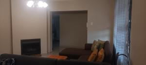 a living room with a couch and a fireplace at Melos Cosy Retreat in Ezulwini