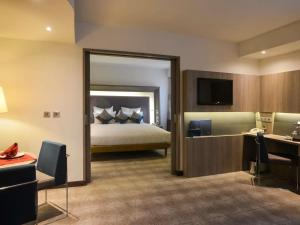 a hotel room with a bed and a television at Novotel Cairo Airport in Cairo +119 photos