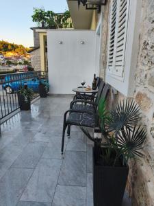 a patio with two chairs and a table on a balcony at Apartman Cvitan in Zaton